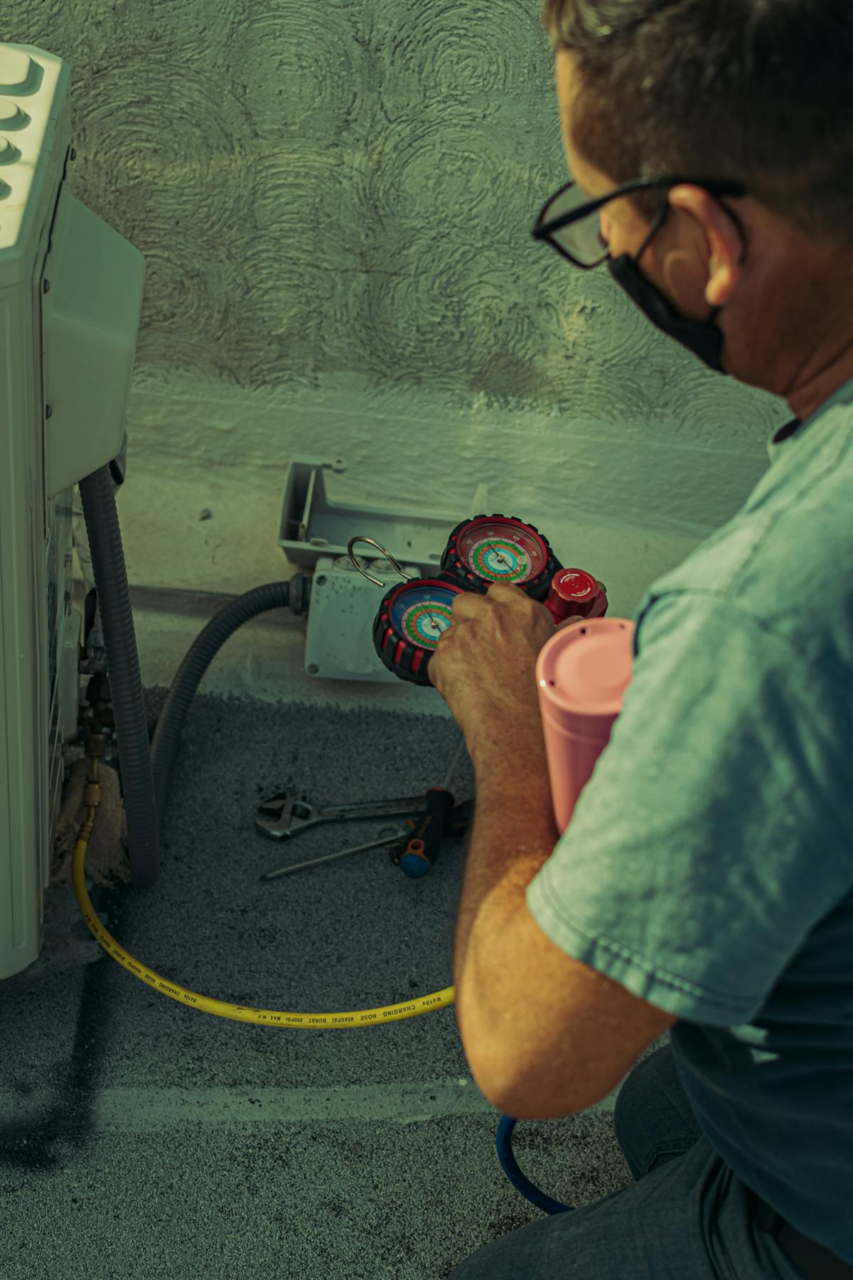 Technician checking refrigerant pressures during HVAC maintenance
