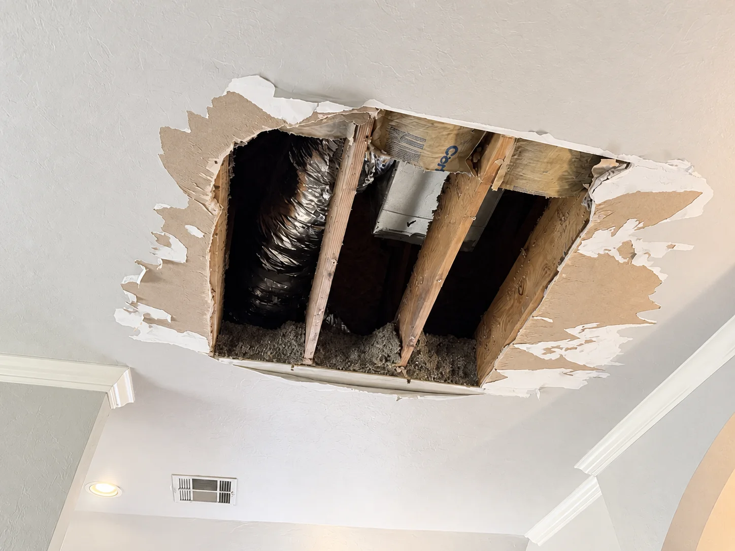Ceiling opened after a backed-up attic HVAC condensate drain caused water damage in an Edmond home