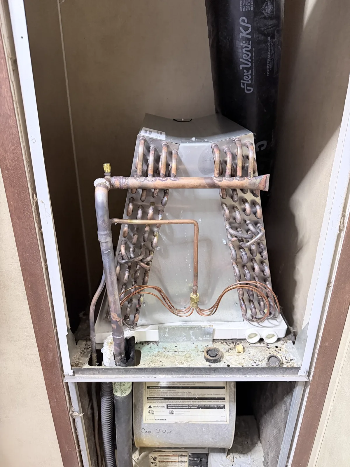 Evaporator coil and copper refrigerant tubing inside the home's indoor HVAC cabinet