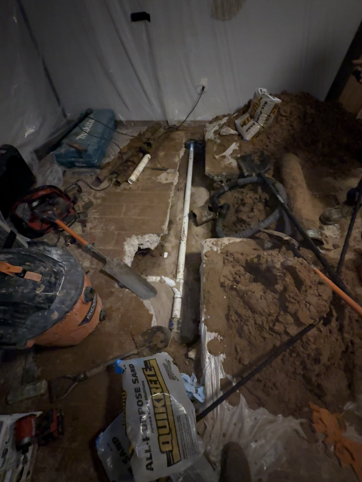 Open trench through an interior concrete slab exposing the underground drain line during TradeStrong sewer work in Moore, Oklahoma